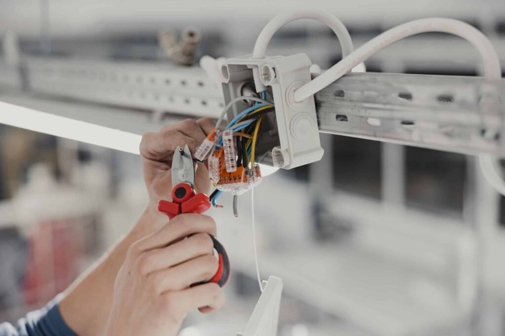 Monteur sluit elektrische bedrading aan in een aansluitdoos