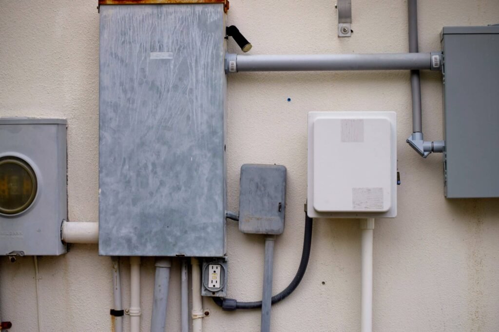Elektrische installatie met meterkast en aansluitkasten aan een gevel
