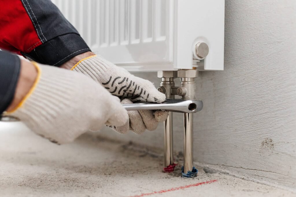 Monteur sluit een radiator aan op de verwarmingsinstallatie