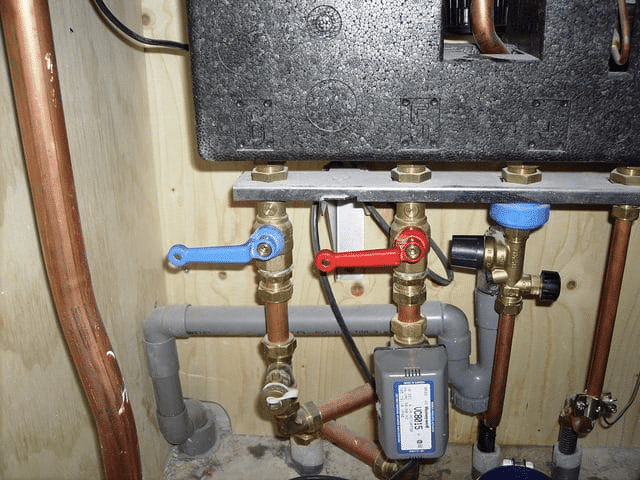 Stadsverwarming aansluiting met warmtemeter, afsluiters en koperen leidingen