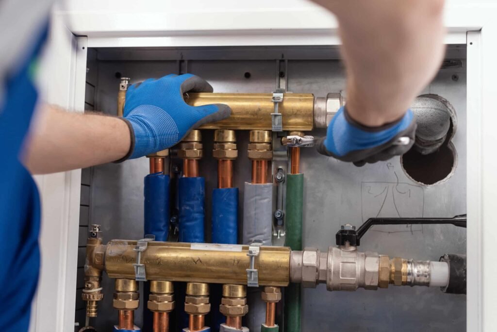 Monteur werkt aan leidingen en aansluitingen van een verwarmingsinstallatie