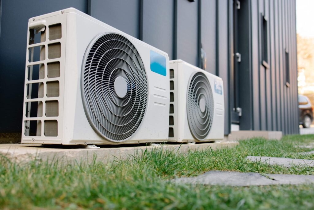 Buitenunits van een warmtepomp naast een woning