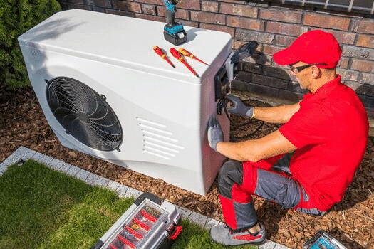 Monteur installeert de buitenunit van een warmtepomp