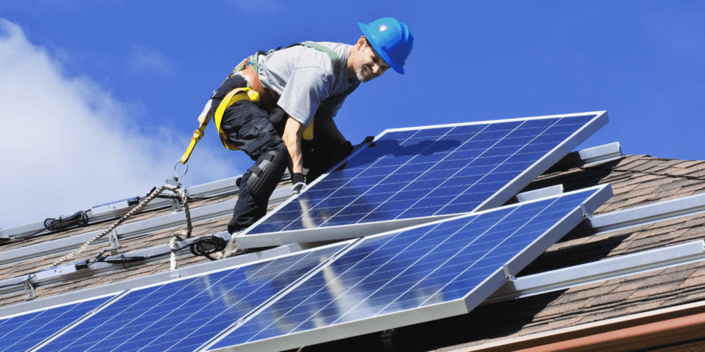 Monteur plaatst zonnepanelen op een schuin dak